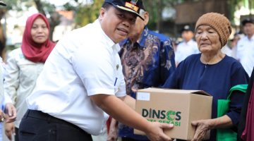 Kepala Dinas Sosial Kota Bekasi Robert Siagian menyerahkan bantuan permakanan kepada seorang warga lanjut usia dalam kegiatan Pendistribusian Permakanan Tahun 2026 di Kecamatan Bekasi Timur, Kota Bekasi, Rabu (16/9/2026). Program tersebut menyasar anak, lansia, dan penyandang disabilitas sebagai bagian dari upaya pemenuhan kebutuhan pangan kelompok rentan.