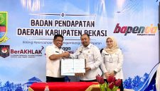 Kepala Bapenda Kabupaten Bekasi Iwan Ridwan bersama perwakilan Kantor Pertanahan Kabupaten Bekasi menunjukkan dokumen Perjanjian Kerja Sama (PKS) pertukaran dan pemanfaatan data pertanahan serta perpajakan daerah. Kerja sama tersebut menjadi langkah awal integrasi data NIB, NOP, dan ZNT untuk mendukung validasi data serta pengelolaan BPHTB di Kabupaten Bekasi.