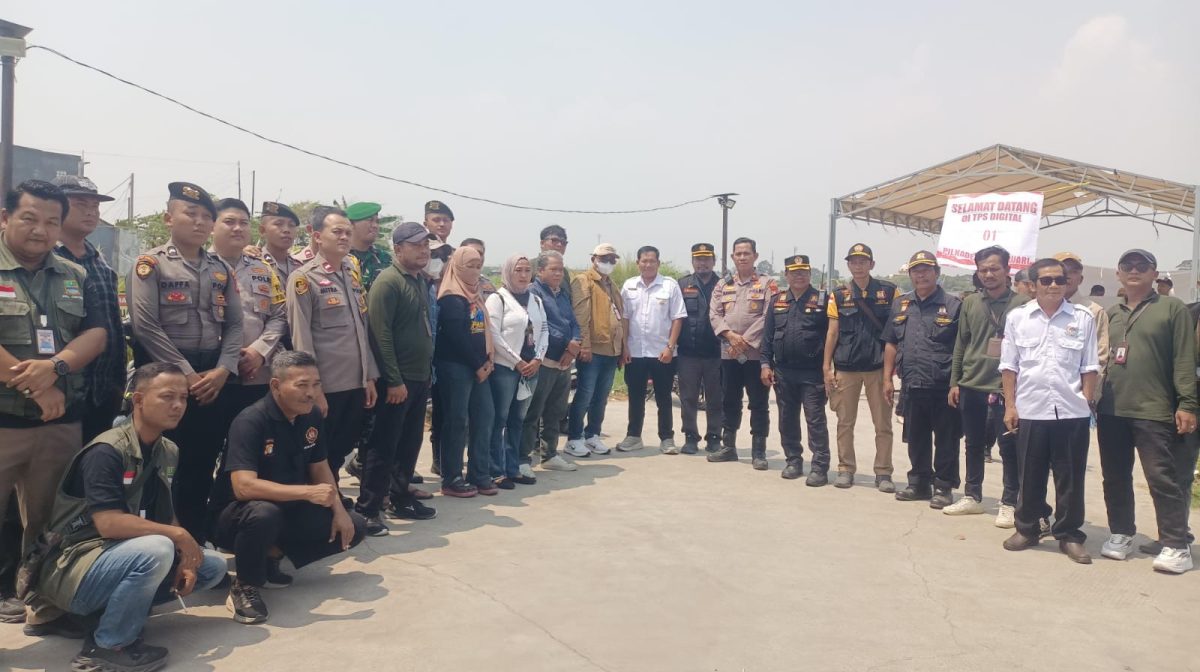 Petugas gabungan bersama Panitia Pilkades dan unsur terkait berfoto bersama di lokasi TPS Digital 01 Desa Muktiwari, Kecamatan Cibitung, Kabupaten Bekasi, Minggu (20/9/2026), saat pelaksanaan Pilkades Serentak 2026. TPS tersebut menjadi salah satu lokasi penerapan sistem pemungutan suara digital.