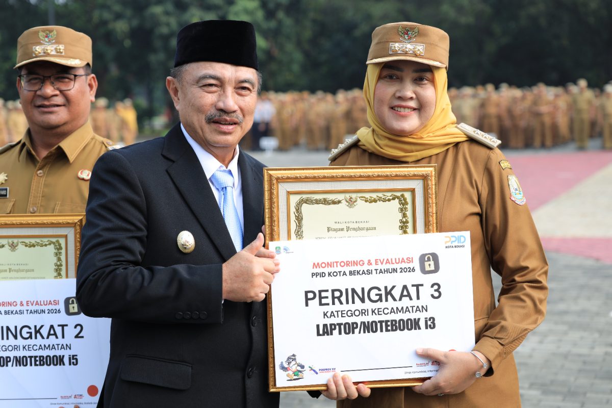 Wali Kota Bekasi bersama perwakilan kecamatan menyerahkan penghargaan hasil Monitoring dan Evaluasi (Monev) Keterbukaan Informasi Publik PPID Kota Bekasi Tahun 2026. Kecamatan Rawalumbu meraih peringkat ketiga kategori kecamatan dalam evaluasi keterbukaan informasi publik. Penyerahan penghargaan berlangsung di Plaza Kantor Wali Kota Bekasi, Senin (12/10/2026).