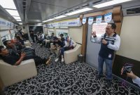 Karyawan XLSMART menjelaskan layanan jaringan 5G kepada peserta di dalam kereta dalam kegiatan pengenalan XL Ultra 5G+. Layanan ini menawarkan konektivitas berkecepatan tinggi untuk mendukung berbagai aktivitas digital masyarakat.