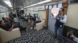 Karyawan XLSMART menjelaskan layanan jaringan 5G kepada peserta di dalam kereta dalam kegiatan pengenalan XL Ultra 5G+. Layanan ini menawarkan konektivitas berkecepatan tinggi untuk mendukung berbagai aktivitas digital masyarakat.