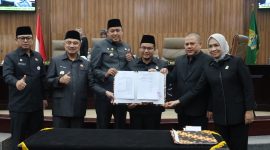 Wali Kota Bekasi Tri Adhianto bersama Wakil Wali Kota Bekasi Abdul Harris Bobihoe dan pimpinan DPRD Kota Bekasi menunjukkan dokumen kesepakatan RAPBD Tahun Anggaran 2027 dalam rapat paripurna di Gedung DPRD Kota Bekasi, Selasa (27/10/2026).
