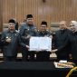 Wali Kota Bekasi Tri Adhianto bersama Wakil Wali Kota Bekasi Abdul Harris Bobihoe dan pimpinan DPRD Kota Bekasi menunjukkan dokumen kesepakatan RAPBD Tahun Anggaran 2027 dalam rapat paripurna di Gedung DPRD Kota Bekasi, Selasa (27/10/2026).