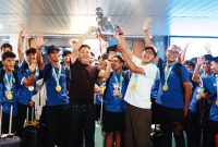 Pemain PERSIB U15 bersama jajaran manajemen dan staf pelatih merayakan keberhasilan menjuarai Piala Soeratin 2026 dengan mengangkat trofi saat tiba di Bandung.