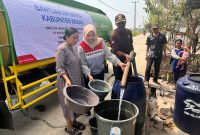 Petugas menyalurkan bantuan air bersih kepada warga terdampak kekeringan di Kabupaten Bekasi. Distribusi air dilakukan untuk membantu memenuhi kebutuhan sehari-hari masyarakat di tengah terbatasnya akses air bersih.