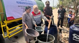 Petugas menyalurkan bantuan air bersih kepada warga terdampak kekeringan di Kabupaten Bekasi. Distribusi air dilakukan untuk membantu memenuhi kebutuhan sehari-hari masyarakat di tengah terbatasnya akses air bersih.