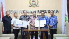 Plt Bupati Bekasi Asep Surya Atmaja bersama Ketua DPRD Kabupaten Bekasi Ade Sukron dan jajaran pemerintah daerah menunjukkan dokumen kesepakatan hasil evaluasi Gubernur Jawa Barat terhadap Perubahan APBD 2026 di Gedung DPRD Kabupaten Bekasi, Senin (19/10/2026).