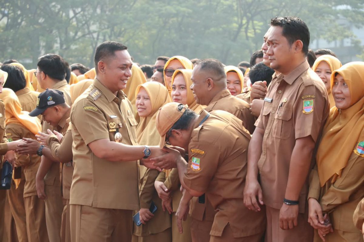 Bupati Bekasi Asep Surya Atmaja bersalaman dengan ASN saat kegiatan apel bersama di lingkungan Pemerintah Kabupaten Bekasi. Dalam kesempatan tersebut, Asep mengingatkan ASN agar menjaga integritas, meningkatkan profesionalisme, dan memastikan penggunaan APBD memberikan manfaat nyata bagi masyarakat.