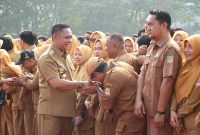 Bupati Bekasi Asep Surya Atmaja bersalaman dengan ASN saat kegiatan apel bersama di lingkungan Pemerintah Kabupaten Bekasi. Dalam kesempatan tersebut, Asep mengingatkan ASN agar menjaga integritas, meningkatkan profesionalisme, dan memastikan penggunaan APBD memberikan manfaat nyata bagi masyarakat.